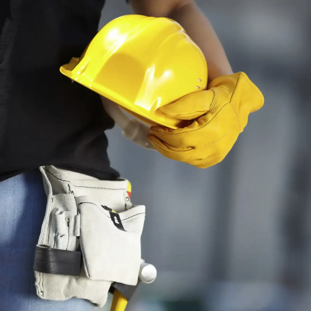 Operatore con casco di sicurezza e guanti da lavoro