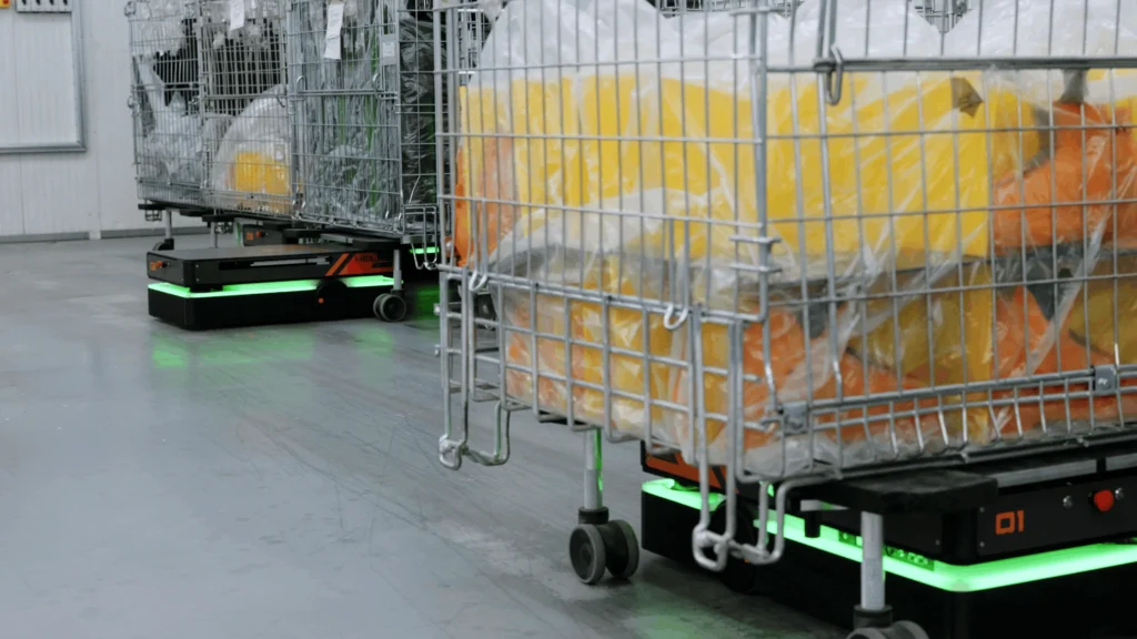AMR HELKO che movimenta un carrello con ceste contenenti semilavorati plastici lungo il reparto produttivo