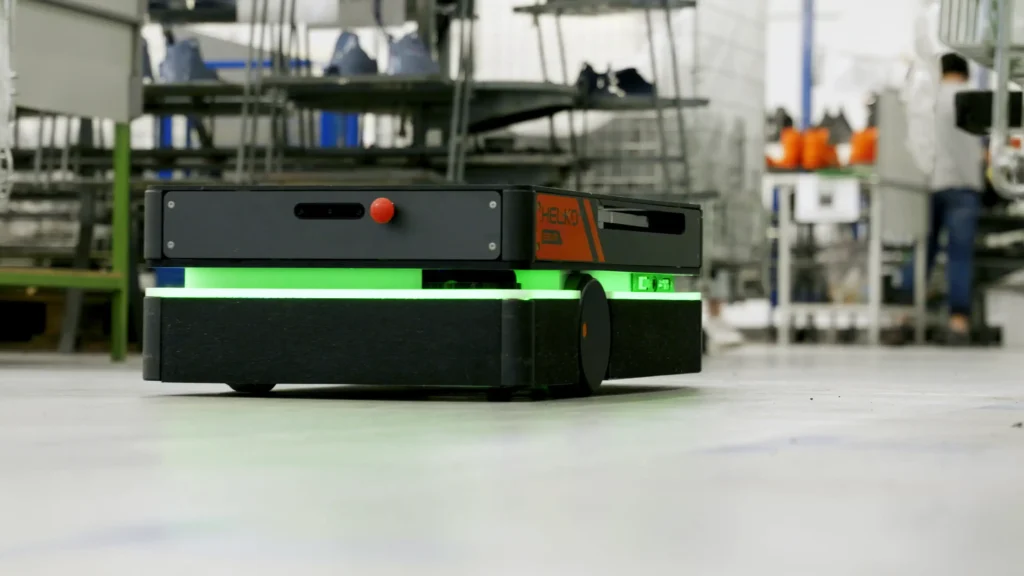Robot mobile HELKO in un'area industriale, pronto a eseguire una missione di trasporto